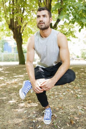 Sportsman stretching body in park