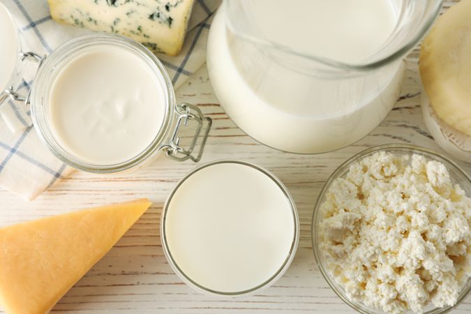 Different dairy products on wooden background, top view