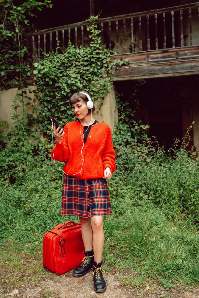 Woman in headphones with suitcase choosing music