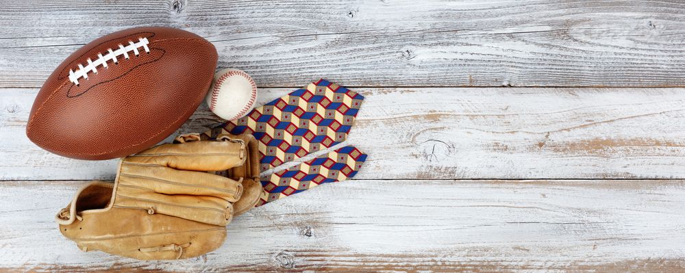 Happy Father’s Day concept with sports items and dress tie on rustic wood with plenty of copy space