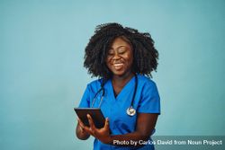 Portrait of smiling Black medical professional dressed in scrubs with tablet 5qOEKb