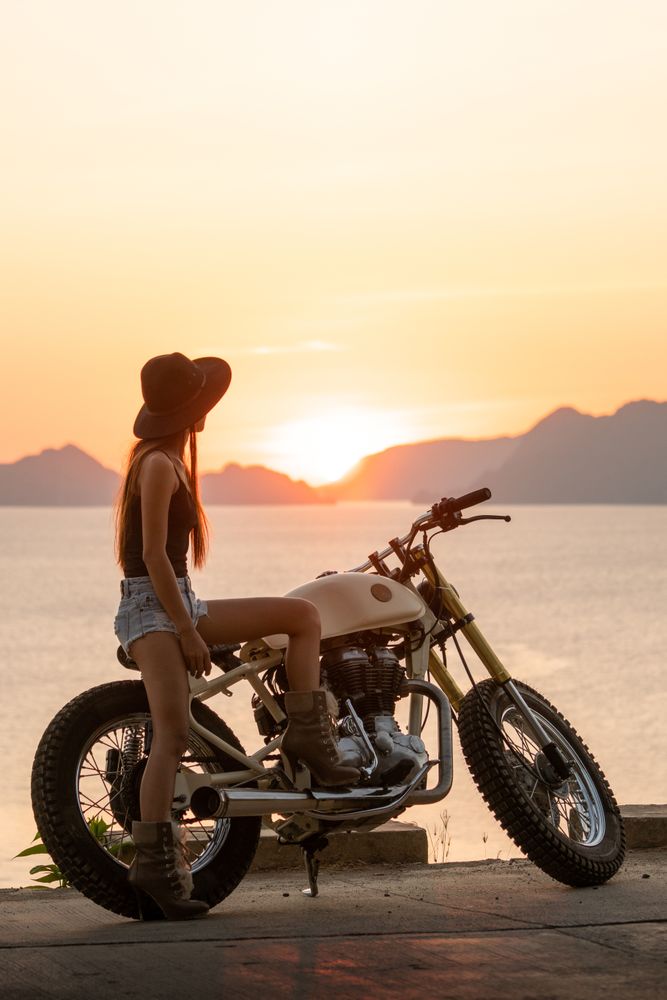 Woman with motorbike near sea