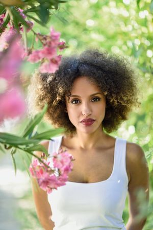 Portrait of beautiful Black woman with afro hairstyle in park, vertical