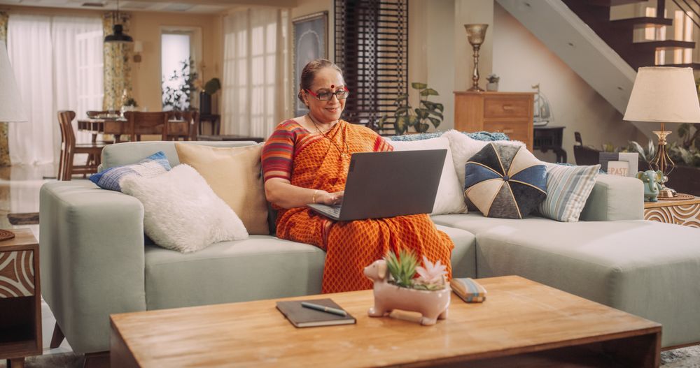 Indian Older Woman Using Laptop at Home: Exploring Online Information, Enjoying Entertainment, and Expanding Knowledge.