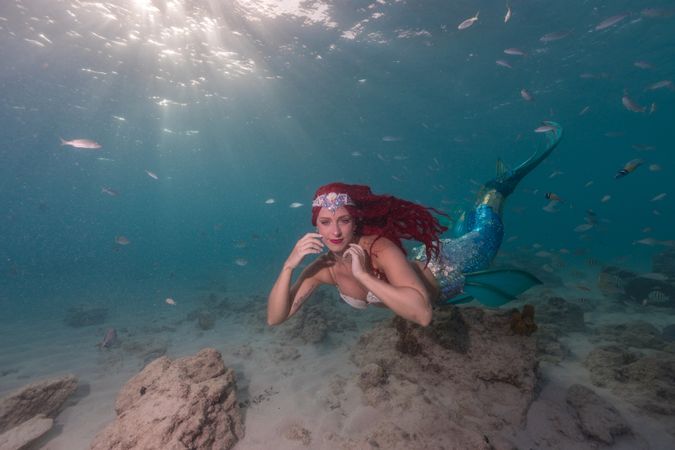 Redhead fairytale female mermaid swimming underwater