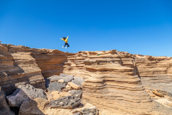 Female jumping for joy in picturesque canyon