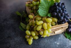 Box of fresh green & red grapes in kitchen