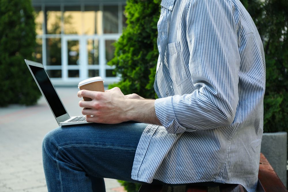 Young student working in a laptop and drinking coffee. Study. University