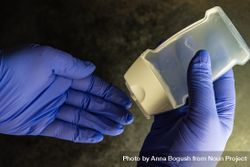 Top view of hands wearing purple latex gloves with antibacterial soap 0v3QRL