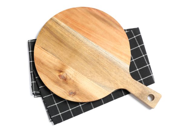 Cutting board with kitchen towel isolated on studio background, top view