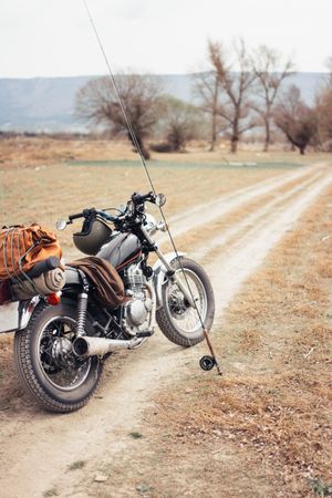 Fishing rod and motorbike on countryside road
