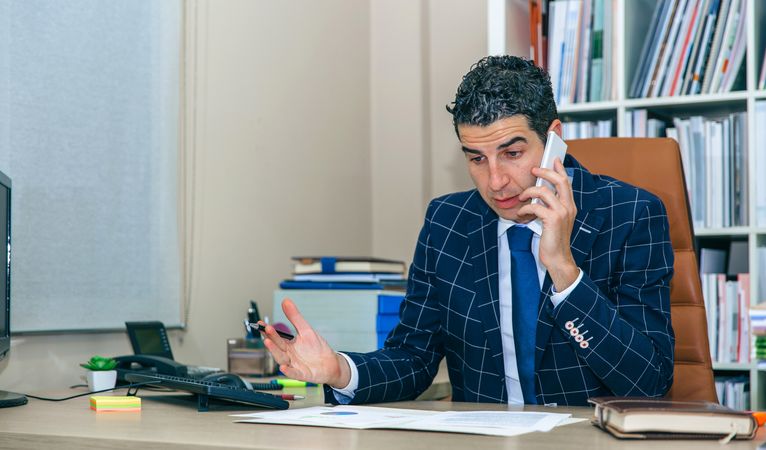 Businessman having heated discussion on phone in office