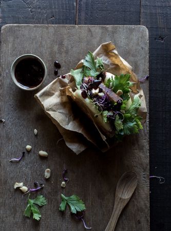 Served Gua Bao sandwich with sauce on board