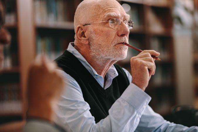 Older man sitting in classroom listening to a lecture with concentration
