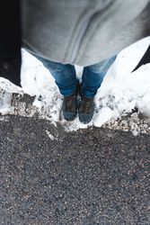 Faceless person standing on snowy road