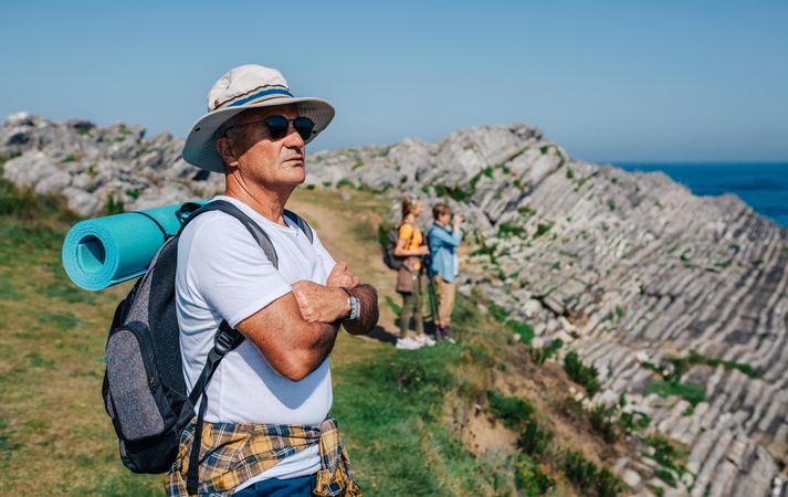 Mature man in foreground of his hiking crew enjoying view