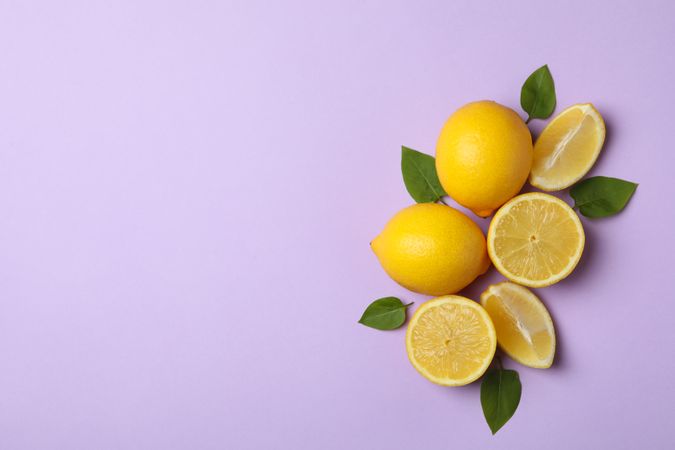 Fresh lemons on violet background, top view. Ripe fruit