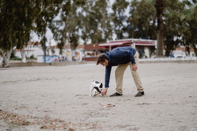 Man and dog playing at beach