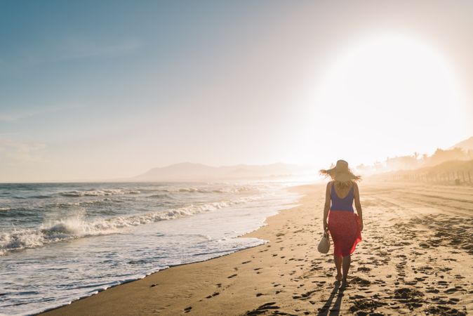 Woman holding walking along seaside