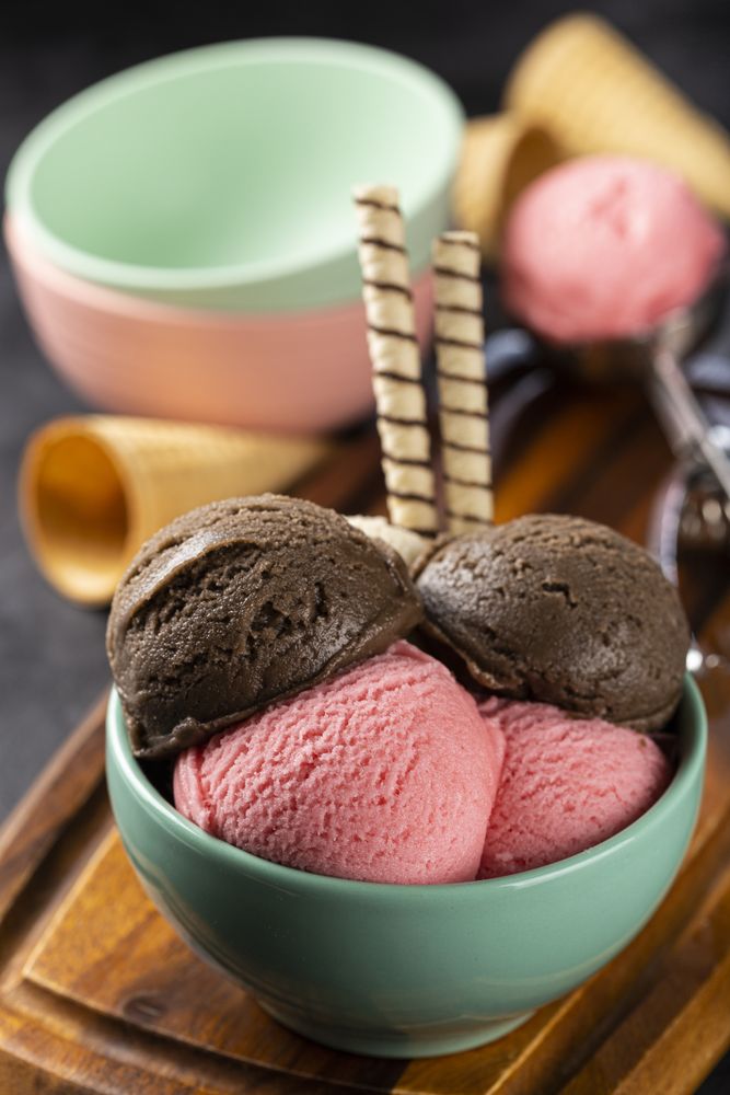 Bowl with Neapolitan ice cream on dark background.