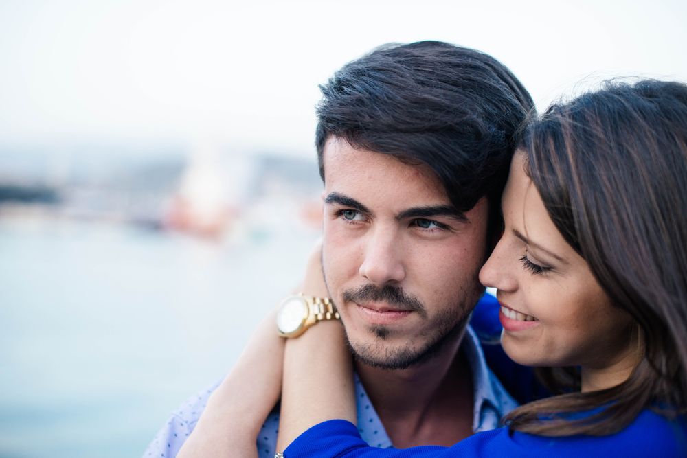 Loving couple embracing on urban pier with dock