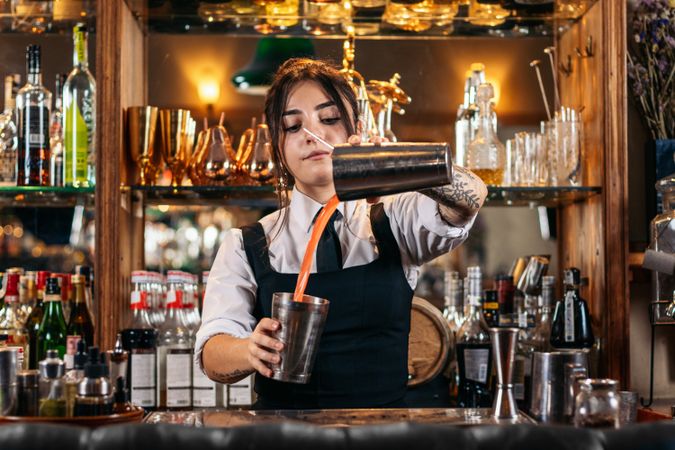 Female bartender preparing a cocktail in a traditional cocktail bar