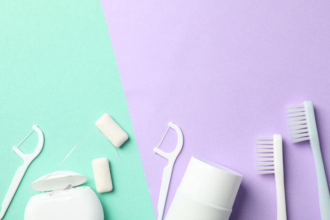 Tools for dental care on two tone background, top view