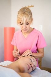 Professional using ear probe pen during skin care treatment in modern beauty salon
