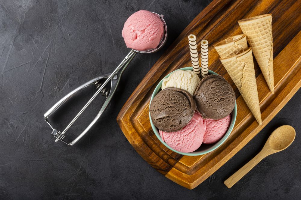 Bowl with Neapolitan ice cream on dark background.