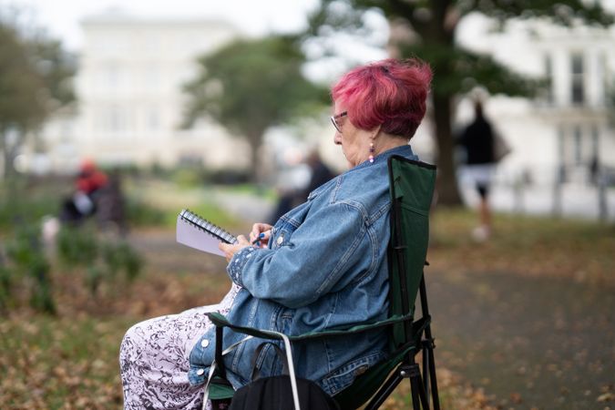 Side view of woman with pink hair drawing