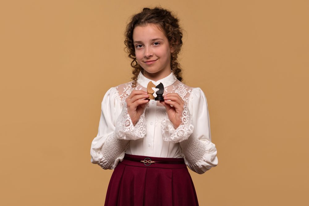 Young girl displaying opposing chess knights