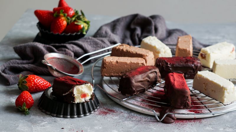 Chocolate and strawberry cakes near bows with ingredients