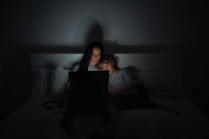 Mother with son doing homework in darkness
