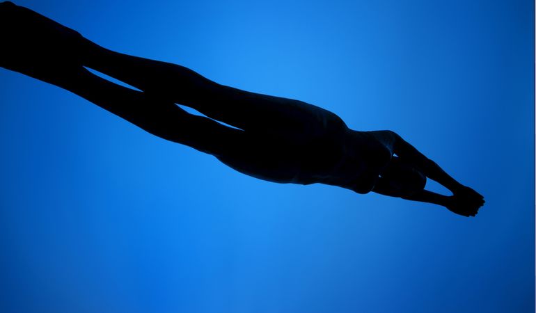 Unrecognizable woman swimming under water