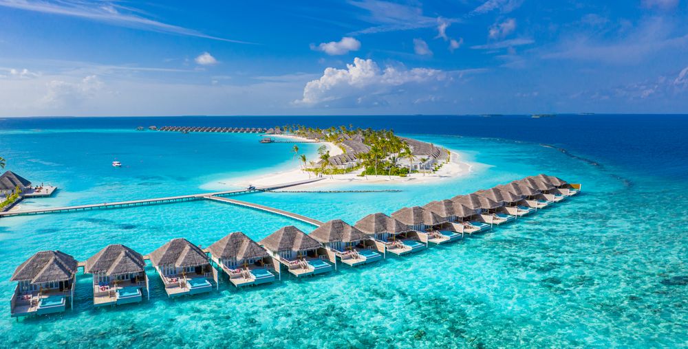Villas lined up in the water of a tropical beach in the Maldives