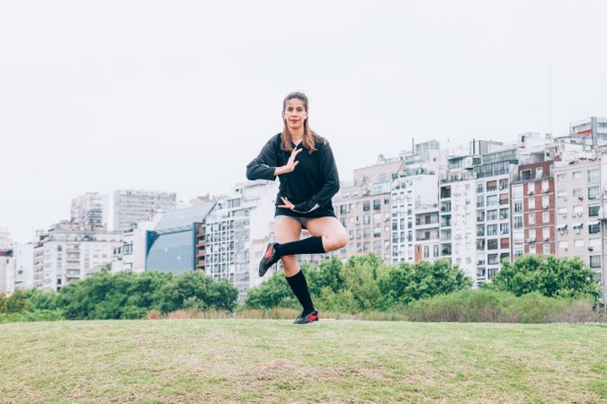 Sportswoman practicing yoga on lawn