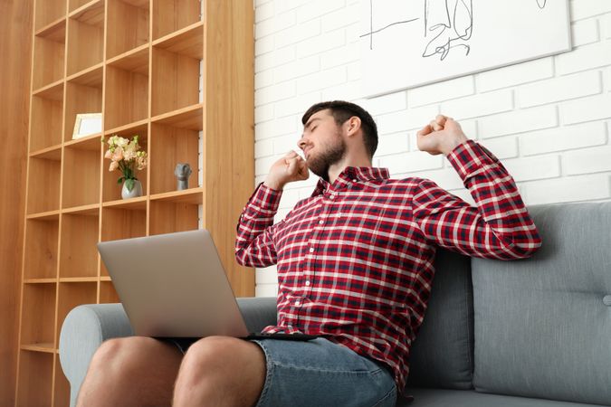 Young man working on laptop in modern flat
