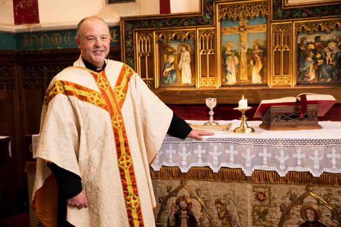 Vicar standing at altar in church