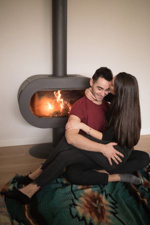 Couple sitting near fireplace on floor