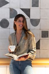 Dreamy woman with book and coffee in cafe
