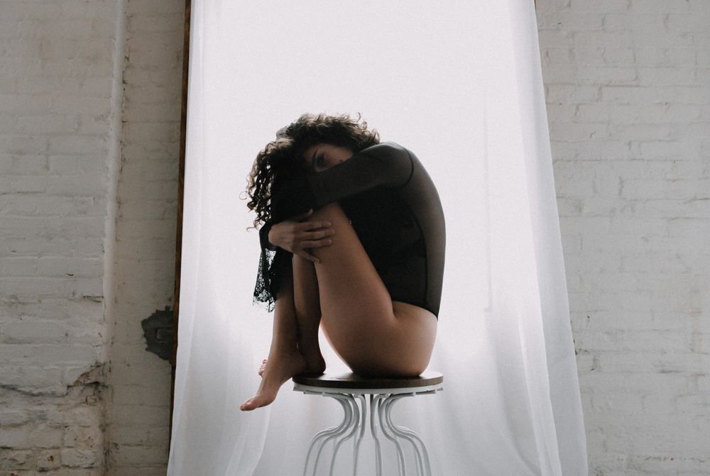Woman with curly hair sitting on table