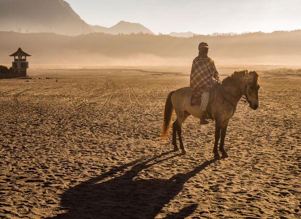 Java Island, Indonesia - August, 14 2015: Anonymous person on horse near volcano
