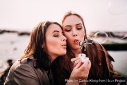 Two young women blowing bubbles outside k4MGE0