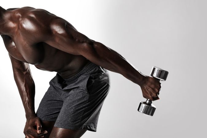 Shot of young fit man doing dumbbell exercise triceps