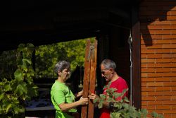 Older couple carrying the ladder together.