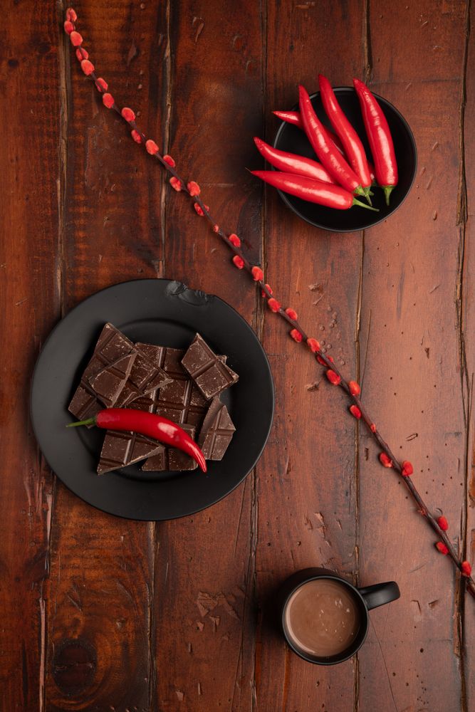 Hot beverage near plate with chocolate and pepper
