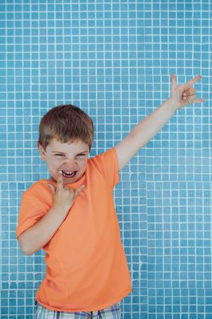 Cheerful playful boy showing sign of rock