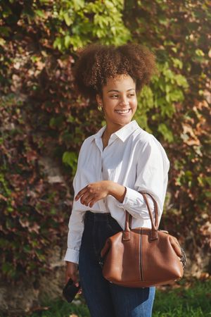 Young Black businesswoman in stylish outfit in park