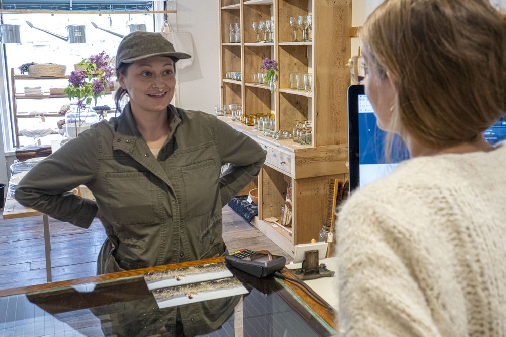 Female gardener talking to female shopkeeper