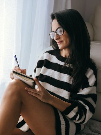 Focused woman taking notes in planner